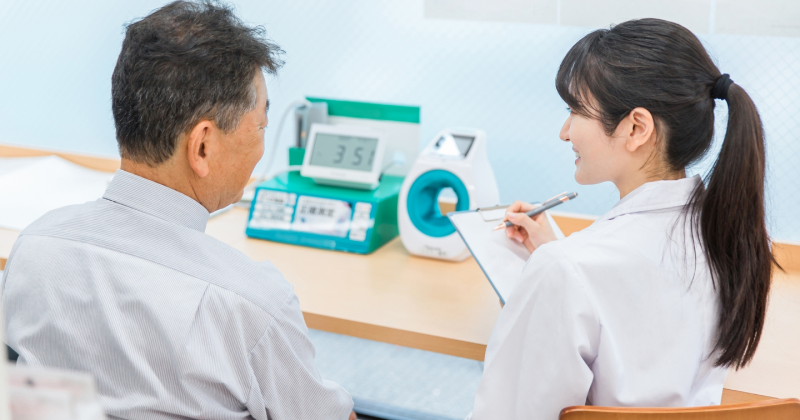 血圧を図っている男性患者と看護師